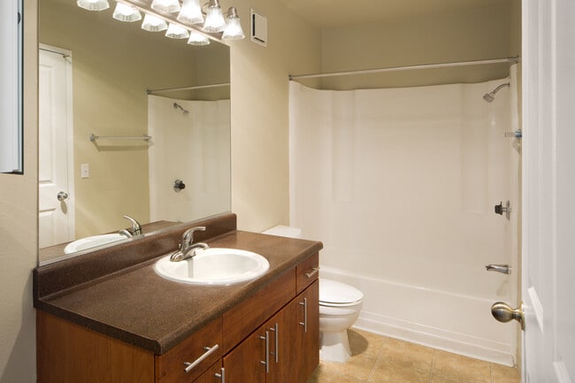 Classic Package II bath with dark laminate countertops, cherry cabinetry, and hard surface flooring