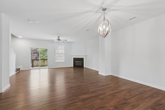 Paquete Clásico Amplios espacios de estar y comedor diseñados para la comodidad: pisos de tablones de vinilo de superficie dura, ventilador de techo y chimenea crean el entorno perfecto - Avalon Townhomes Brier Creek
