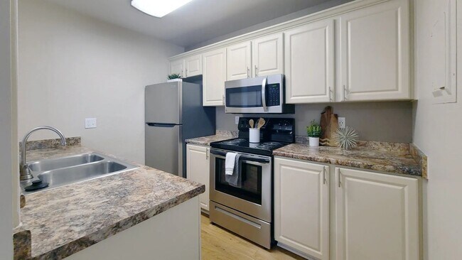 Prepare meals with ease in this thoughtfully updated kitchen featuring stainless steel appliances, contemporary cabinetry, and ample counter space.