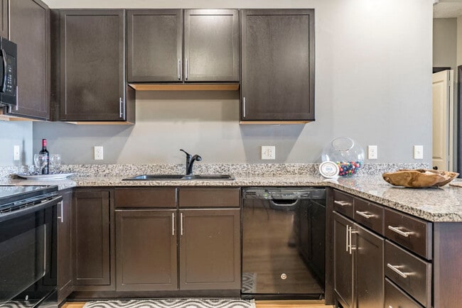 Our Espresso design style features rich, dark cabinetry and light granite countertops. - The Flats at 84