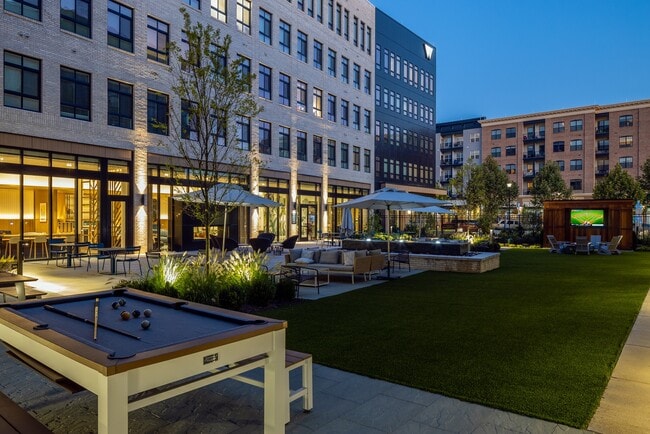 Wellsmith western courtyard with gaming tables, seating, and an outdoor theater