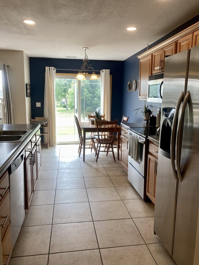 kitchen and dining with patio access - 906 SE Crossings Ln