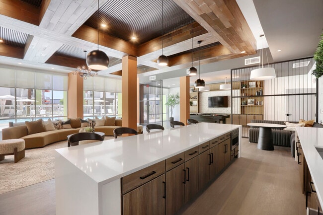 Open, social, and connected to the outdoors. The clubhouse lounge flows from the bar island to curved sectional seating with direct views of the resort-style pool.