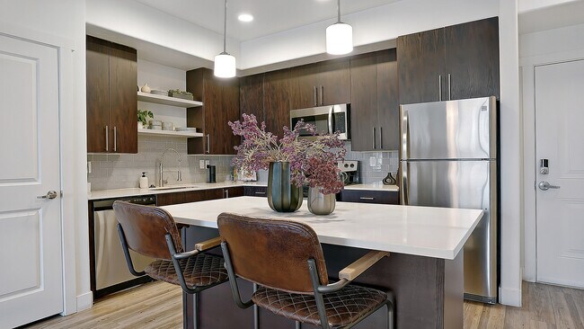 Large kitchen island with seating and modern pendant lighting.