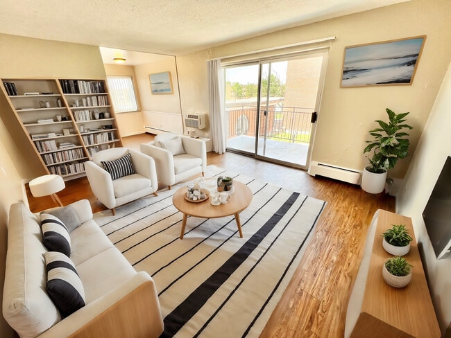 Sala de estar luminosa y acogedora con muebles elegantes, una elegante estantería y un amplio balcón con vista, perfecto para la vida en un apartamento moderno. - Bonneville Apts