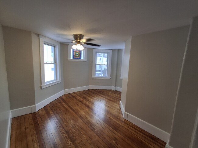 Dining Room: Refinished hardwood flooring, brand-new ceiling fan, original stained-glass window. - 13 Mulberry St Unit #2
