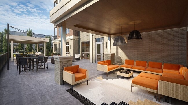 Covered outdoor seating area with lounge furniture and nearby grilling stations.