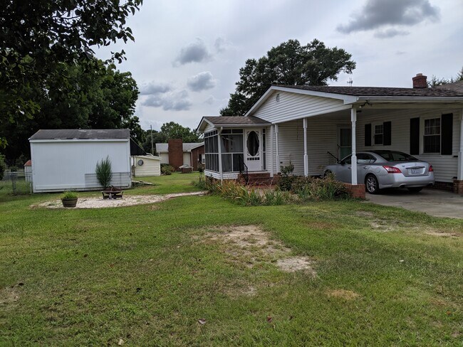 Back of home with screen porch, 2nd driveway, carport, and firepit area - 17241 Wagram Rd