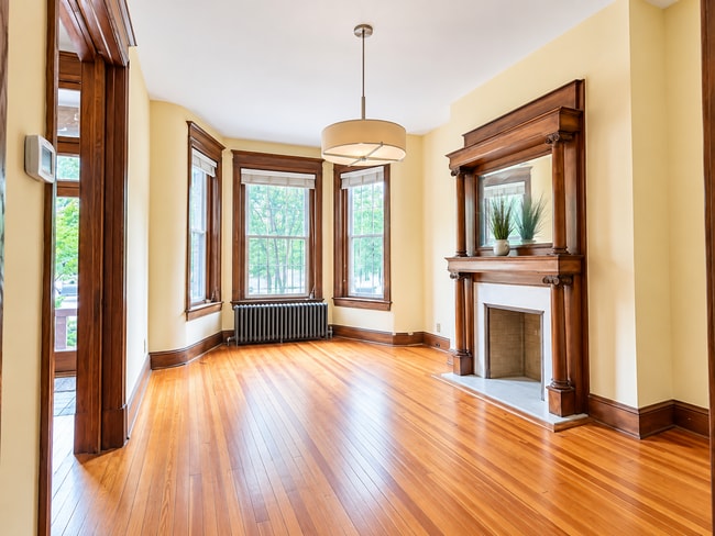 Sun filled living room with original hardwood floors, bay windows and decorative fireplace - 2322 1st St NW