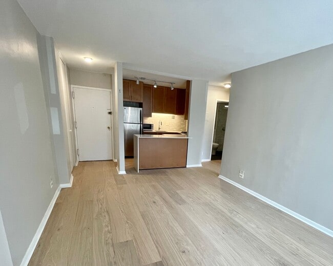 Living room view to kitchen; new wood floors - 1260 21st St NW Unit Newport Apartment