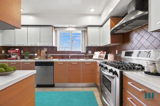 Cocina de chef de tamaño completo con electrodomésticos de acero inoxidable y amplio espacio de almacenamiento en gabinetes. - Brockton Palace by Wiseman