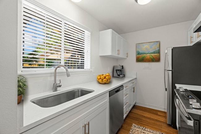 Experience culinary bliss in this modern, sunlit kitchen designed for functionality and style.