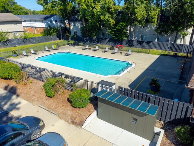 Open and heated pool space with lounge chairs and 24/7 secured package lockers at Knottingham Apartments in Clinton Township, MI - Knottingham Apartments