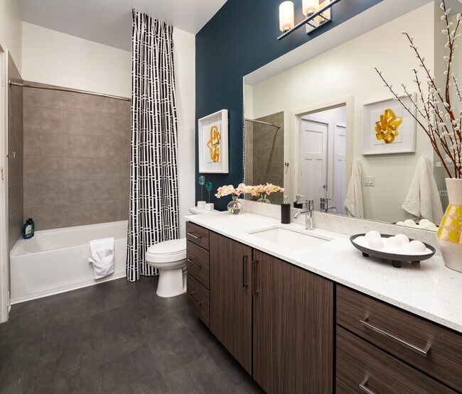 One long mirror above the vanity doubles the light thrown by the sconce.
