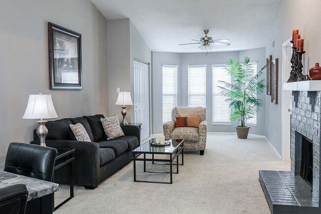 Wood Burning Fireplace and Large Windows in Living Room - Willowbend Apartments