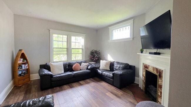 Bright, inviting living room with comfortable seating, electric fireplace, and 55" Smart TV.