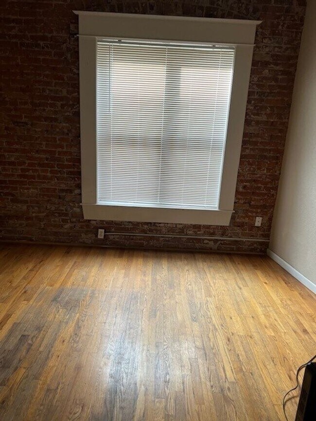 Photo - Large windows and exposed brick wall Unit 305
