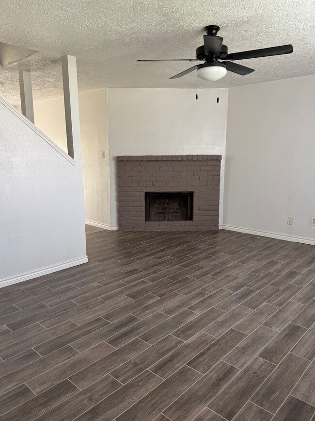 Bright living space featuring stylish wood-look flooring and a cozy fireplace accent wall.
