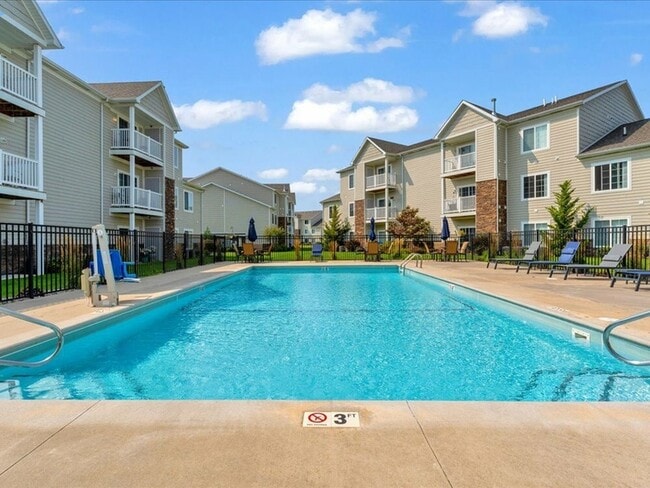 Sparkling outdoor pool with deck and lounge chairs - The Haven at Grand Landing
