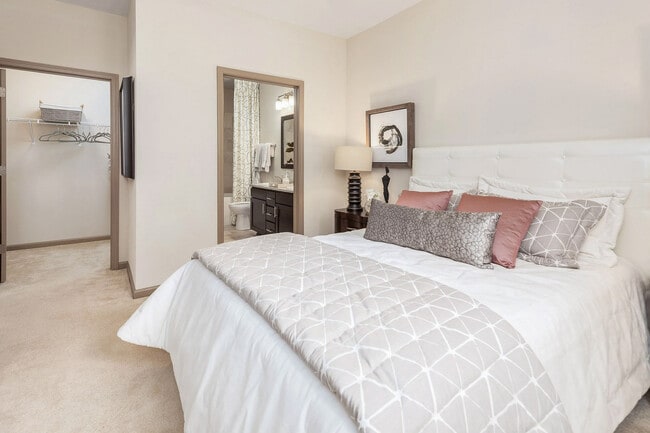 Spacious primary bedroom with large closet and en-suite bathroom—comfortable, modern apartment living in Charlotte.