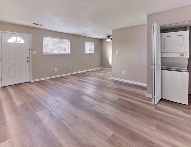Spacious living area with natural light and in-home washer and dryer at Village Square. - Village Square