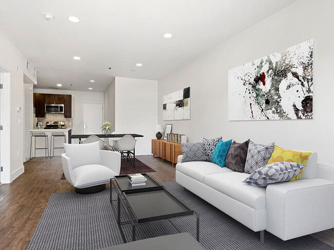 Hardwood floored living room with can lights and view of kitchen. - Bonita Terrace Apartments