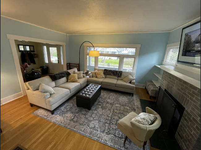 The living room offers a cozy, comfortable space with two large couches and a TV, perfect for unwind - 3012 N 22nd St House