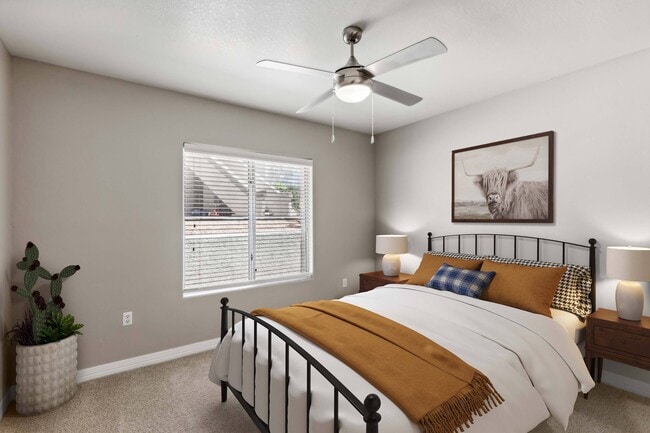 Bedroom with ceiling fan and plush carpeting