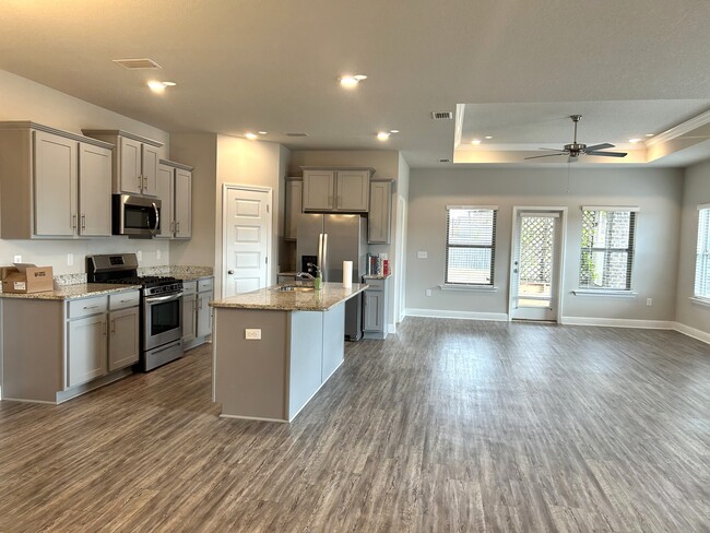 Open concept kitchen/living/dining area with center island to offer additional seating - 31524 Plover Ct House