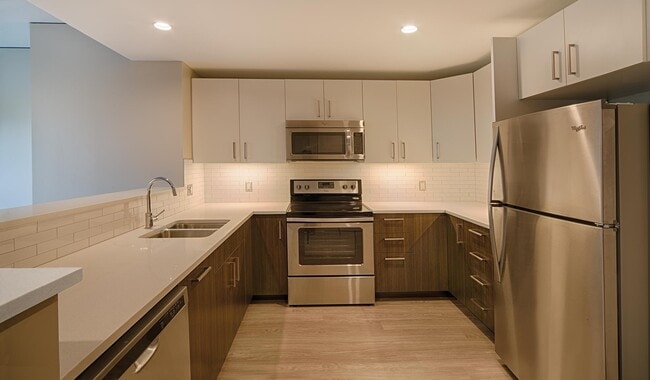 Modern kitchen with stainless steel appliances and quartz countertops