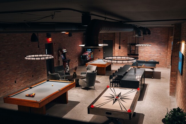 Community game room featuring billiards, ping pong, air hockey, pinball, a bar area, and virtual golf simulator