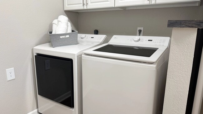 Thoughtfully integrated into the apartment layout, this dedicated laundry area features full-size washer and dryer appliances and additional overhead storage.