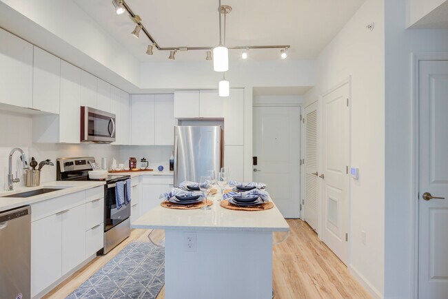 East Phase Kitchen with white cabinetry, white countertops, stainless steel appliances, and hard surface flooring - Avalon Miramar Park Place