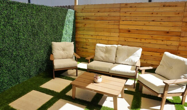 Backyard oasis with fake turf, boxwood wall, and string lights installed - 5230 Brinkman Ct