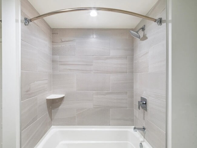 Sleek tile surrounds and polished fixtures bring a refined touch to bathrooms at Modera Aventura.