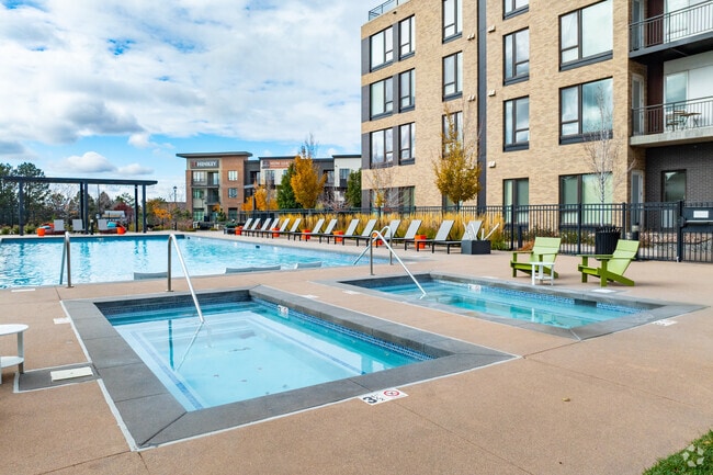 Piscina del complejo con jacuzzi y cenadores