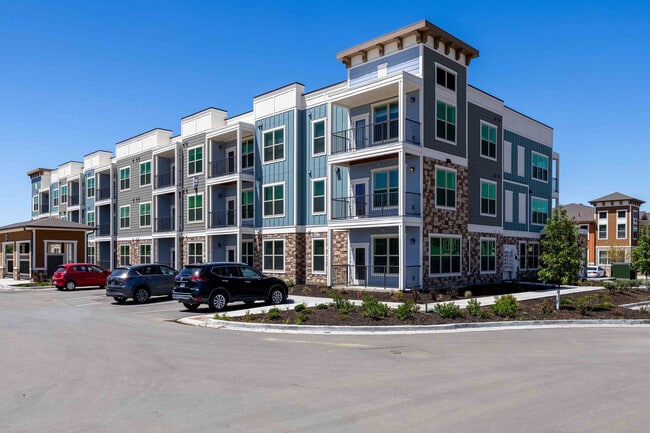 Los edificios residenciales de tres plantas de Garrett Parker combinan piedra, revestimiento y detalles de paneles en una comunidad ajardinada en Parker, Colorado.