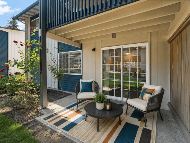 A stylish private patio with modern outdoor seating and peaceful courtyard views at Chambers Pointe Apartments.