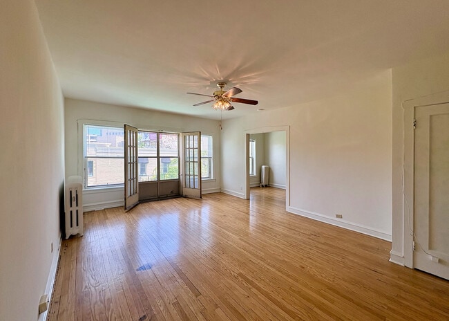Inviting living room with elegant hardwood floors, ample natural light, and charming French doors. Perfect for relaxation and entertaining.