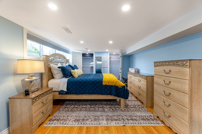 The bedroom offers a luxurious queen bed, two dressers, double closets and a luggage rack. - 1191 Pharmacy Av Unit Basement