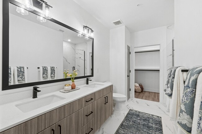 Bathroom with Quartz Countertops, Double Vanity Sinks, Walk-in Shower, and Walk-in Closet