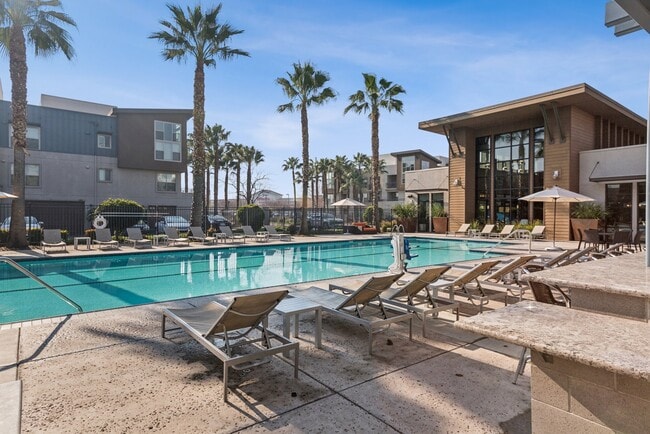 Aspire Apartments Tracy California Luxury Living A large swimming pool in front of a building with palm trees.