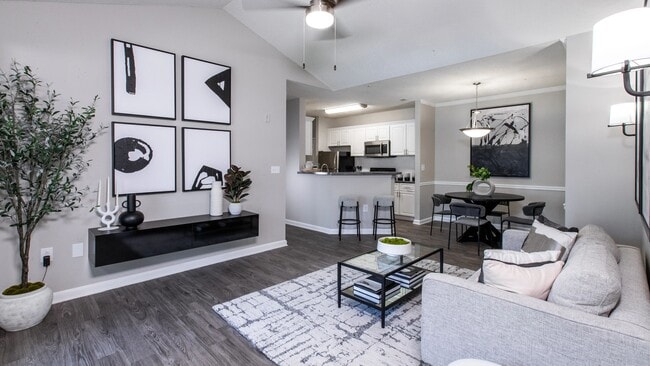 Delight in the luxury of our expansive living rooms featuring rich wood-style flooring and modern ceiling fans with lights. - The Everlee