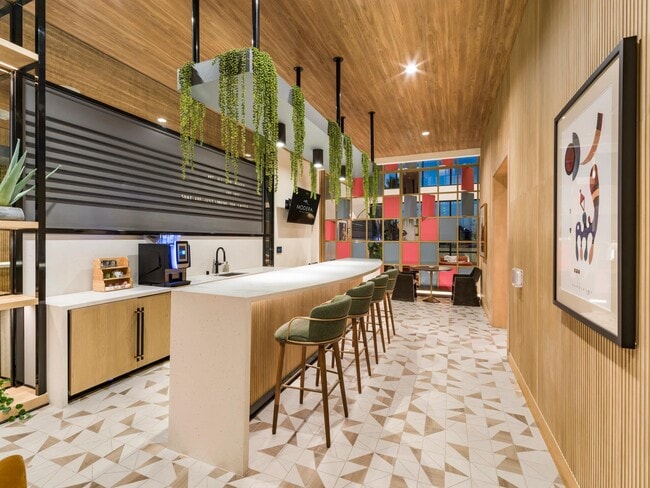 Coffee bar and coworking hub with a communal island, café-style seating, and thoughtfully designed spaces that support productivity, connection, and daily convenience.