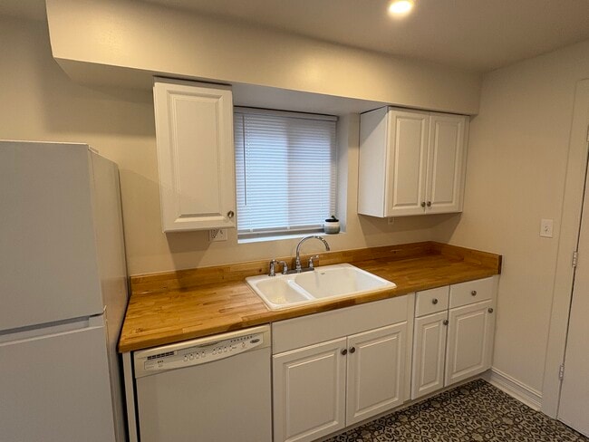 Original cast iron sink paired with butcher block countertops - 6035 Oakwood Ave