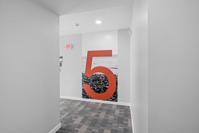 This room features a bold and unique design with a large red number 5 on the wall, adding character to the space. - Harbor Flats