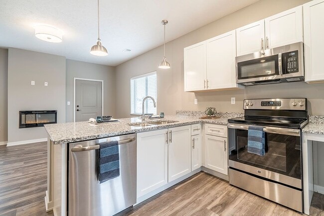 Our contemporary design scheme features white cabinetry and light granite countertops