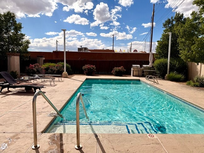 Pool area landscaped with vibrant flowering plants - 1900 Central Ave SW