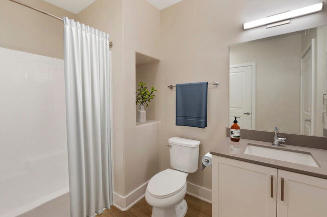 Renovated Package III bath with grey quartz countertops, white cabinetry, and hard surface flooring