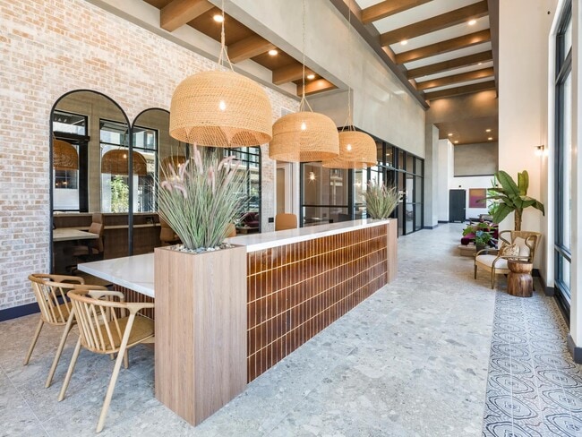 A warm welcome starts here—our leasing lounge blends modern textures with desert-inspired design for a fresh take on hospitality. - Modera Higley Commons